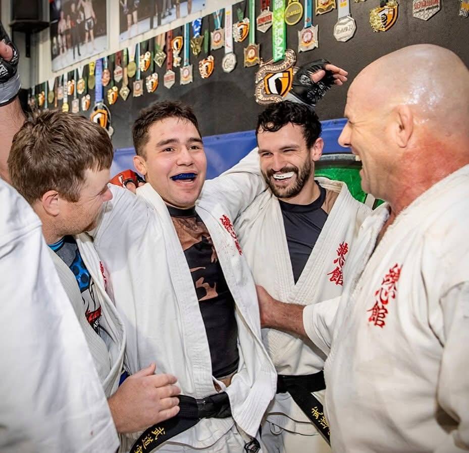 Black belts in Mildura Martial Arts uniforms celebrating together after training