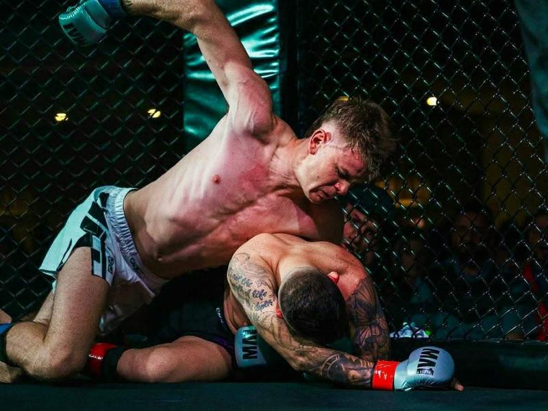 A Mildura fighter on top in the cage during an MMA bout